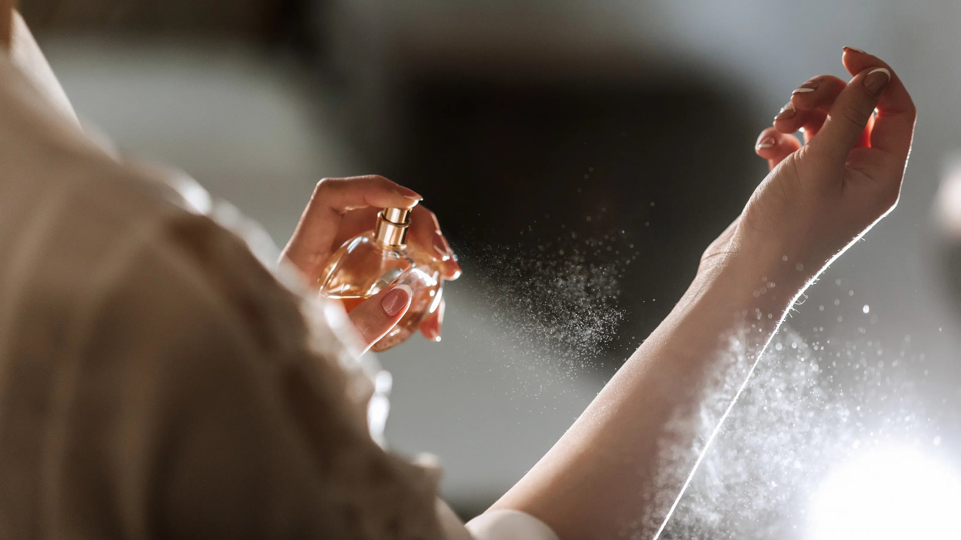 Woman spraying a perfume on her wrist.
