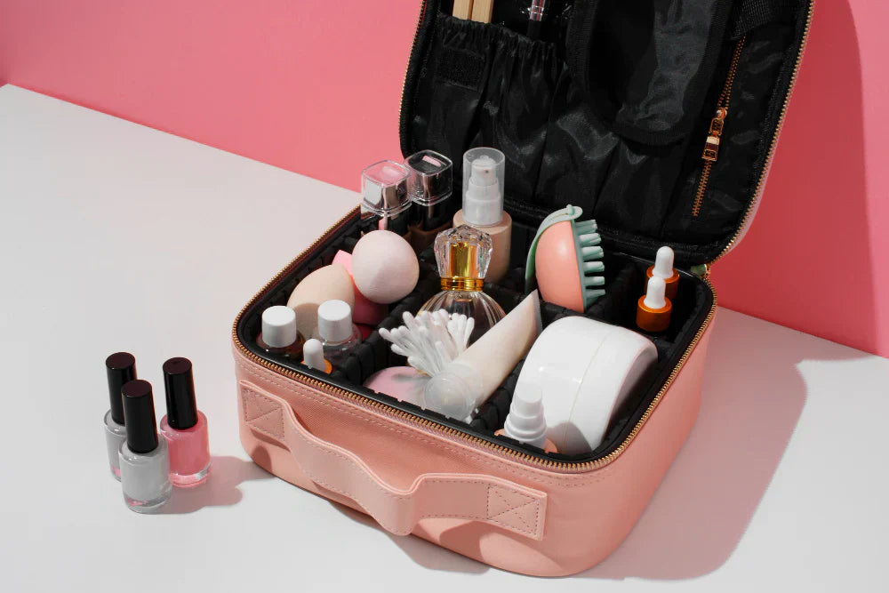 Various cosmetic products and a perfume bottle inside a small pink suitcase.