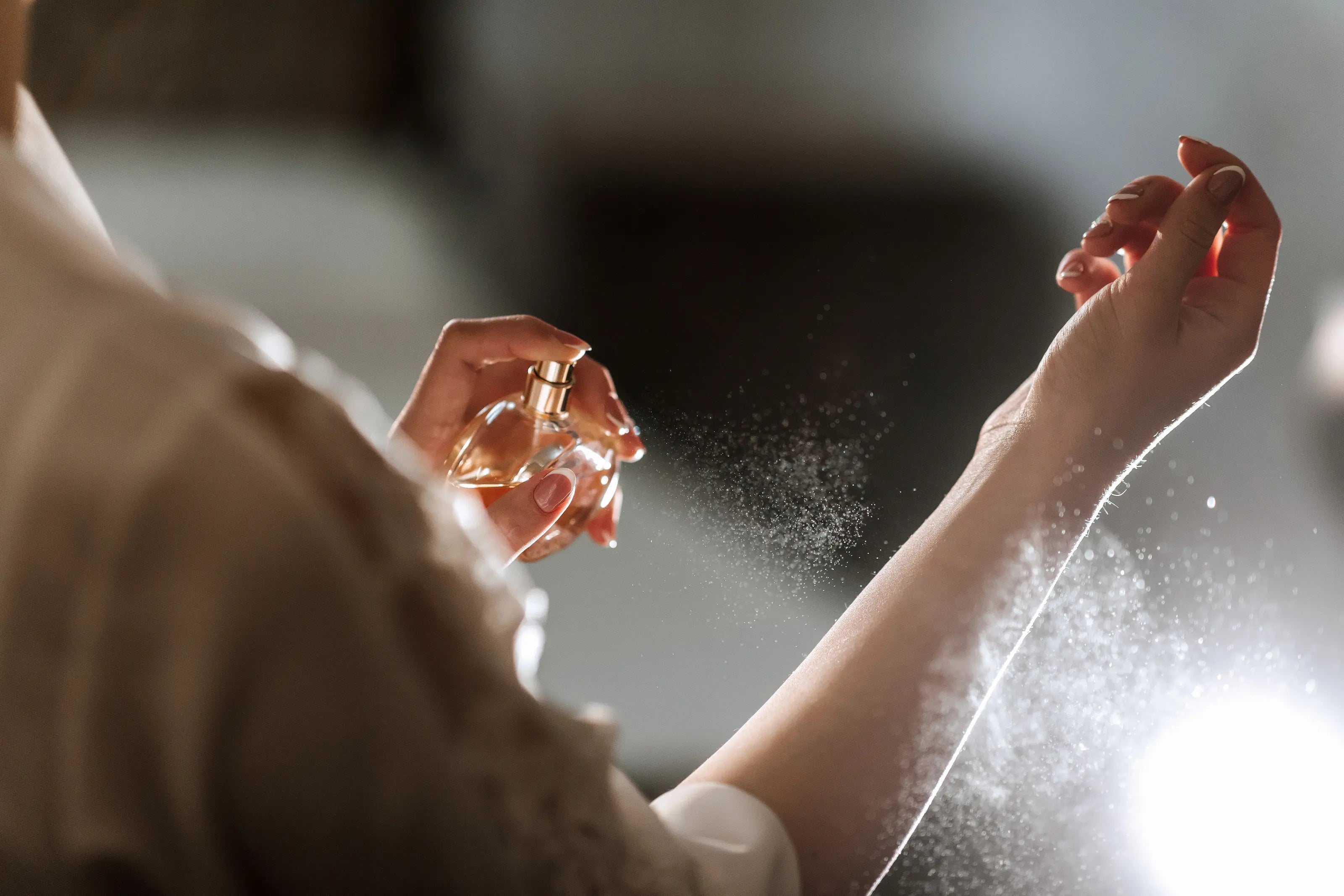 Woman spraying a perfume on her wrist.