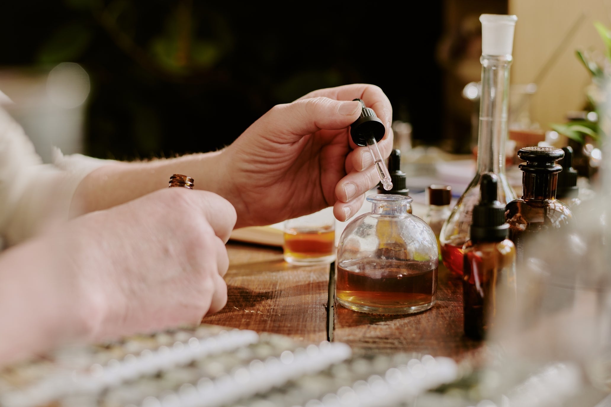 Person carefully measuring perfume oil.